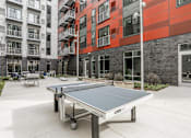 Thumbnail 26 of 87 - a ping pong table in the lobby of a building with pipes on the wall at Beekman on Broadway, Ann Arbor, Michigan