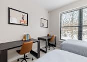 Thumbnail 74 of 87 - A bedroom with a bed, desk, and chair.