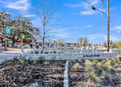 Thumbnail 45 of 46 - A sign that says "Charles Park at Sunset Ridge" is in front of a tree.