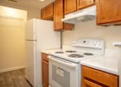 Thumbnail 10 of 21 - a kitchen with white appliances and wooden cabinets and a refrigerator