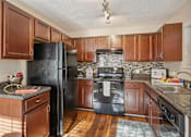 Thumbnail 16 of 32 - Kitchen with wooden cabinets at Radbourne Lake Apartments, Charlotte, 28269