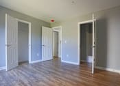 Thumbnail 21 of 21 - an empty living room with wood floors and white doors