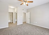 Thumbnail 39 of 54 - A room with a ceiling fan and carpeted floor.