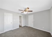 Thumbnail 26 of 37 - an empty room with a ceiling fan and a door to a closet