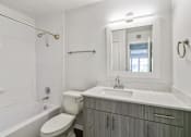 Thumbnail 26 of 29 - A bathroom with a toilet, sink, and tub.