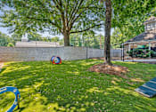 Thumbnail 13 of 29 - A playground with a slide, ball and a tree.