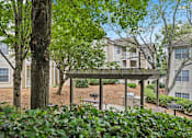 Thumbnail 14 of 29 - A tree stands in front of apartment buildings.