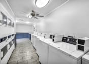 Thumbnail 15 of 41 - a laundry room with many washers and dryers and a ceiling fan