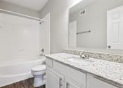 Thumbnail 38 of 54 - A white bathroom with a tub, toilet and sink.