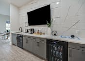 Thumbnail 4 of 29 - A modern kitchen with a black TV mounted on the wall.