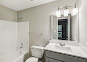 Thumbnail 23 of 35 - A white bathroom with a toilet, sink, and bathtub.