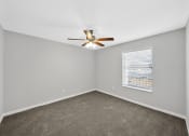 Thumbnail 25 of 37 - an empty room with a ceiling fan and a window