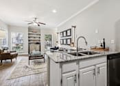 Thumbnail 3 of 54 - A kitchen with a marble countertop and a ceiling fan.