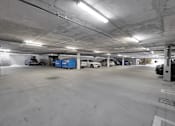 Thumbnail 12 of 20 - A parking garage with several cars parked inside.