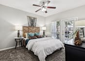 Thumbnail 6 of 54 - A bedroom with a large bed and a ceiling fan.