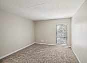 Thumbnail 22 of 35 - A room with a carpeted floor and a window with blinds.