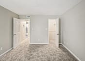 Thumbnail 20 of 35 - A room with carpeted floor and three doors.