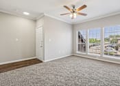 Thumbnail 45 of 54 - A room with a ceiling fan and carpeted floor.