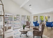 Thumbnail 3 of 35 - A living room with a white couch, a brown chair, and a blue chair.