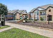 Thumbnail 26 of 54 - A playground area in front of a row of houses.