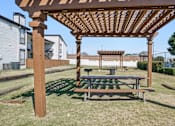 Thumbnail 28 of 31 - Wooden pergola with a bench underneath it at Keller Oaks, Carrollton, TX 75006