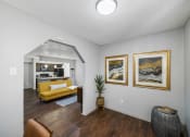 Thumbnail 21 of 37 - a living room with a yellow couch and two paintings on the wall