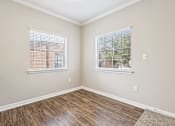 Thumbnail 33 of 54 - A room with wooden floors and two windows.