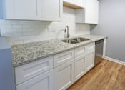 Thumbnail 18 of 21 - an empty kitchen with white cabinets and a sink