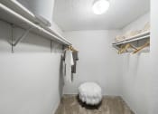 Thumbnail 26 of 37 - a walk in closet with a white furry chair