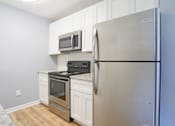 Thumbnail 19 of 21 - a kitchen with stainless steel appliances and white cabinets
