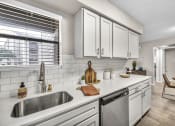 Thumbnail 23 of 41 - an open kitchen with white cabinets and a sink