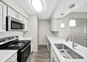 Thumbnail 3 of 37 - a kitchen with white cabinets and a stainless steel sink