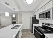 Thumbnail 28 of 37 - a kitchen with white countertops and stainless steel appliances