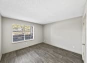Thumbnail 30 of 37 - a bedroom with hardwood floors and a large window