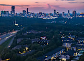 Thumbnail 19 of 80 - A cityscape at dusk with a mix of residential and commercial buildings.
