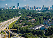 Thumbnail 20 of 80 - A cityscape with a highway running through a residential area.