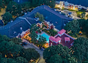 Thumbnail 24 of 80 - A nighttime aerial view of a residential area with houses and trees.