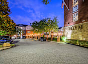 Thumbnail 32 of 80 - A gym is located in a parking lot with a brick building.