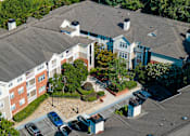 Thumbnail 39 of 80 - A large building with a parking lot in front.