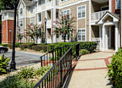 Thumbnail 43 of 80 - A street view of a residential building with a black metal fence.