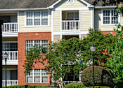 Thumbnail 44 of 80 - A building with a red brick wall and a white balcony.