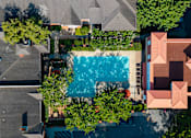 Thumbnail 50 of 80 - A swimming pool surrounded by trees and buildings.