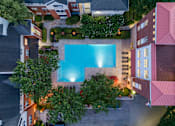 Thumbnail 2 of 80 - A swimming pool surrounded by buildings and trees.