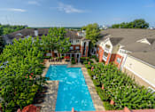 Thumbnail 51 of 80 - A swimming pool surrounded by trees and houses.