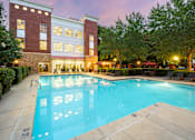 Thumbnail 1 of 80 - A large swimming pool in front of a red brick building.