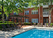 Thumbnail 5 of 80 - A pool surrounded by lounge chairs and trees.