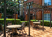 Thumbnail 7 of 80 - A patio with a table and chairs under a pergola.