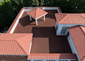 Thumbnail 56 of 80 - A building with red roofs and a white section on the side.