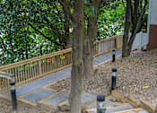 Thumbnail 61 of 80 - A wooden deck with a railing and a tree in the foreground.