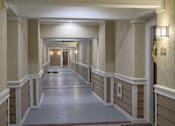 Thumbnail 75 of 80 - A long hallway with a red carpet and white walls.